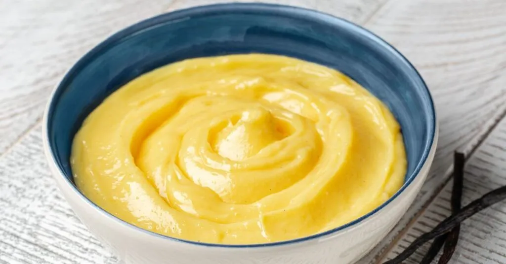 A blue bowl full of yellow custard.