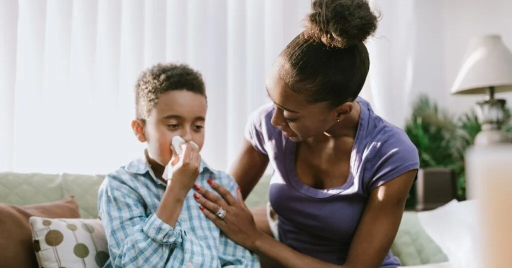 A mother comforts her coughing son.