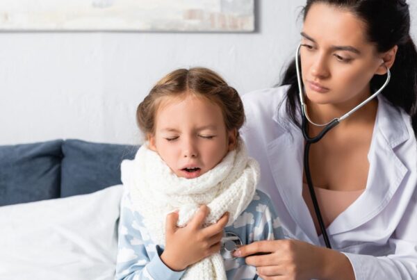 A sick girl is examined by a doctor.