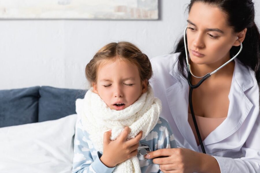 A sick girl is examined by a doctor.
