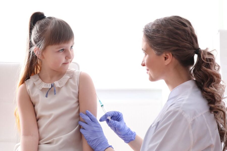 A doctor gives a girl a vaccine.