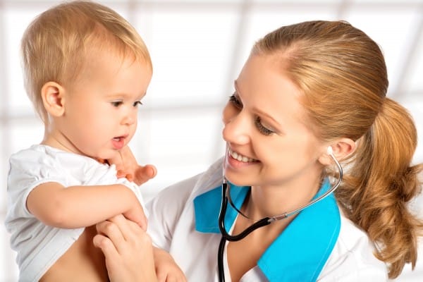 A physician listens to her young patient's heartbeat with a stethoscope.