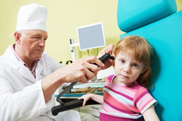 Medical otolaryngologist ear nose throat doctor examining little girl