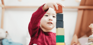 A young boy plays with colorful building blocks.