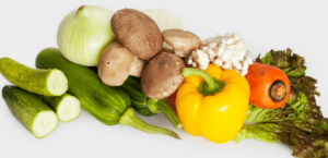 Several top food sources of Vitamin A on a table, including bell peppers, mushrooms, and squash.