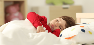A boy sleeps in his bed.