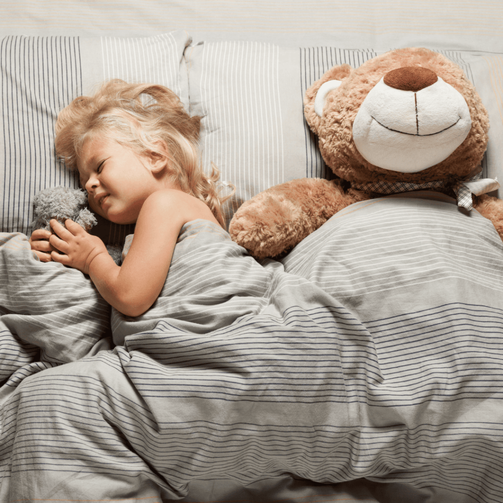 A young child struggles to fall asleep while laying in bed.
