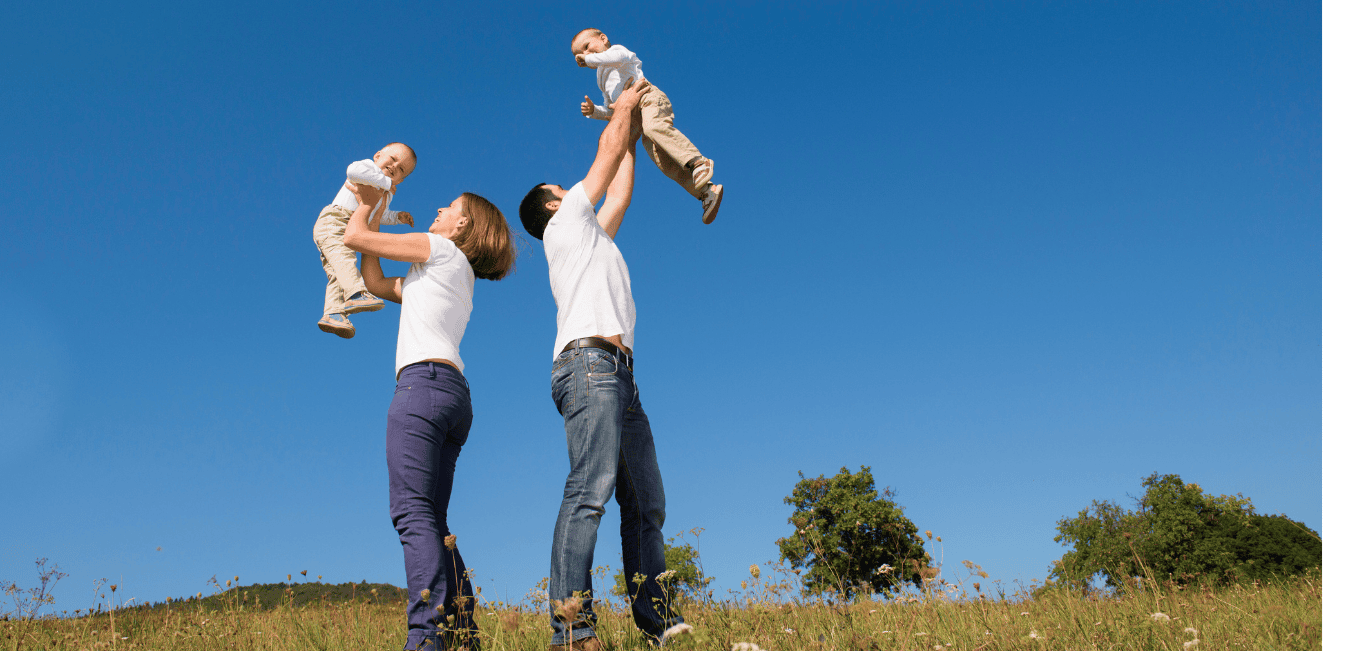 A family plays together outdoors on a cloudless day.