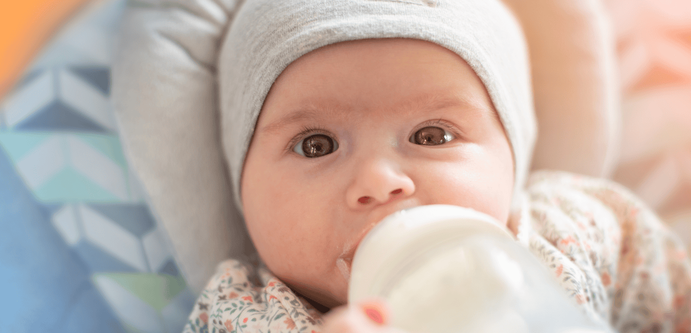 A baby drinks a bottle of formula.