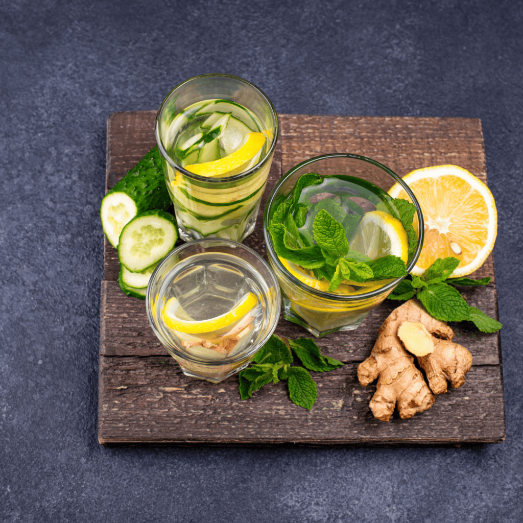 Three glasses of water with lemon, ginger, cucumber, and basil. (Detoxification drink)