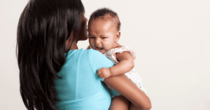 A mother holds her colicky, crying baby.