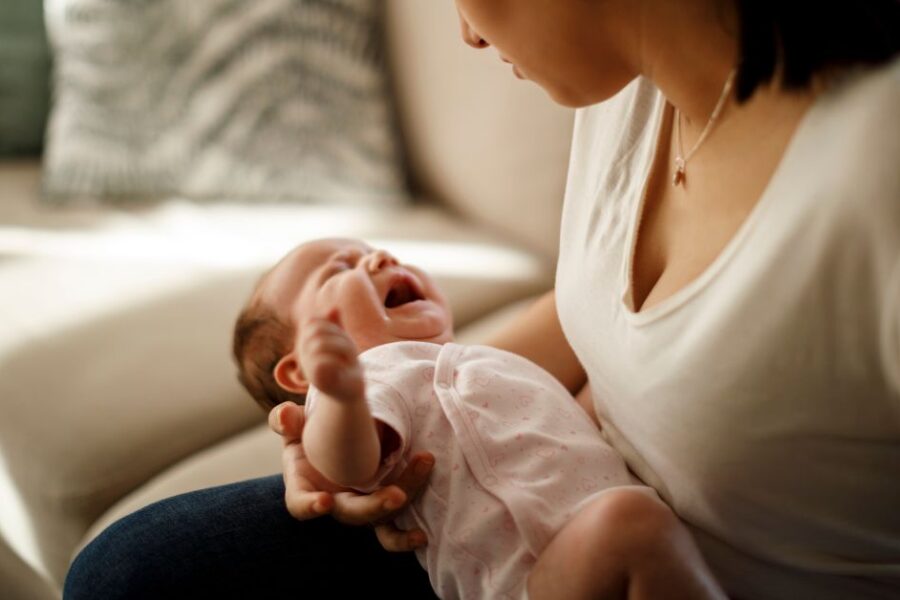 A mom holds her crying baby.