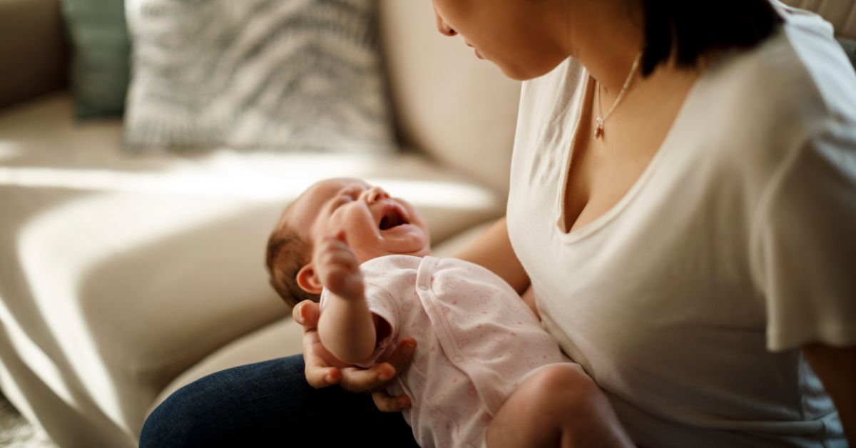 A mom holds her crying baby.