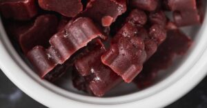 A white bowl filled with homemade elderberry gummies.