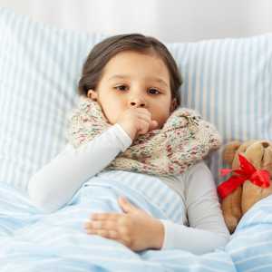 An ill child lays in bed wrapped in warm blankets.