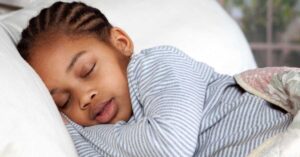 A young child sleeps peacefully in bed.