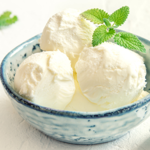A bowl of homemade ice cream with a sprig of mint.