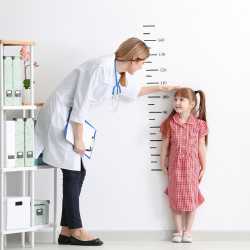 A small child is measured for height by a pediatrician.