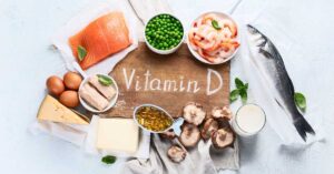 Dietary sources of vitamin D, such as fish, eggs, and milk, lay on a table.
