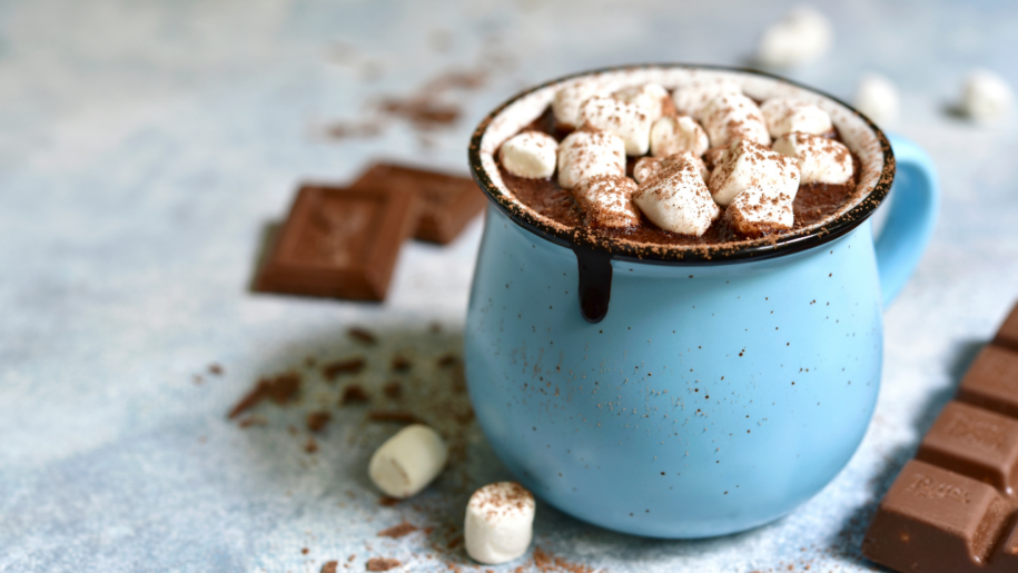 A blue cup of hot chocolate topped with marshmallows.