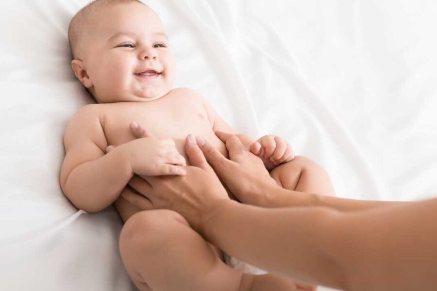 Photo of a mom giving an infant an abdominal massage.
