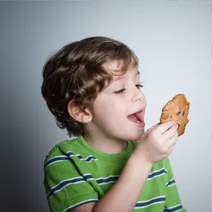 A boy eats a cookie.