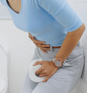 A woman clutches at her stomach in pain. 