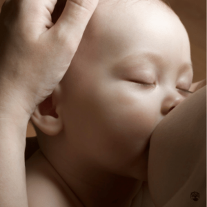 A baby nurses from a breast.