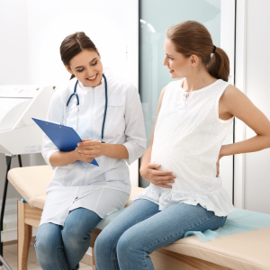 A pregnant woman discusses important matters with her doctor.