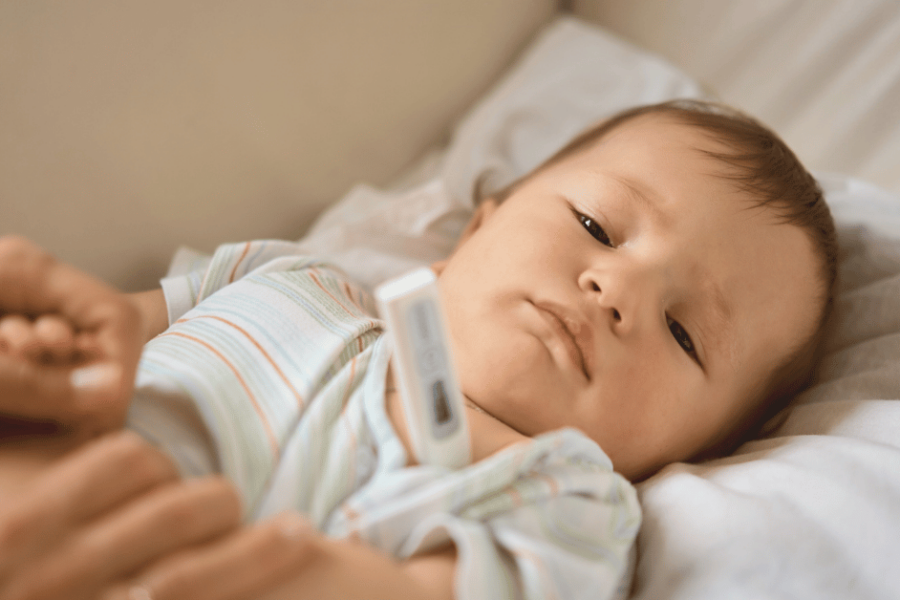 A sick baby gets their temperature taken.