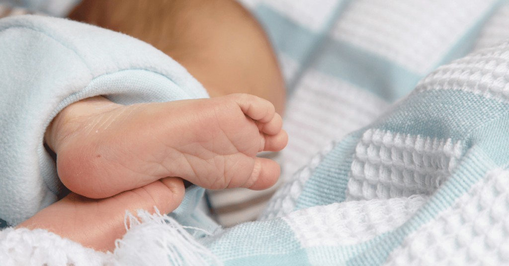 An infant's foot with a small puncture in the heel for newborn screening.