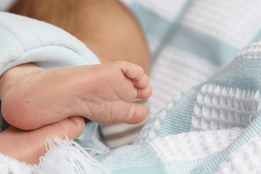 An infant's foot with a small puncture in the heel for newborn screening.