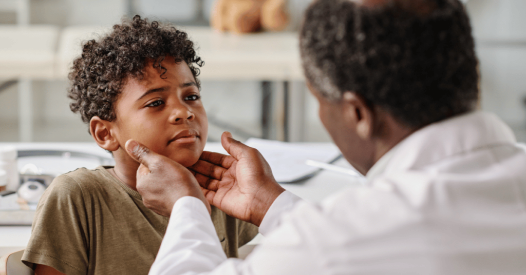 A doctor looks at a boy's throat and tonsils.