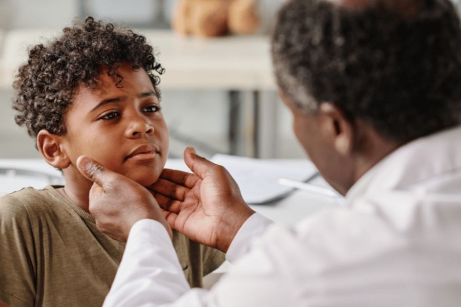 A doctor looks at a boy's throat and tonsils.