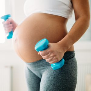 A pregnant woman lifts weights.