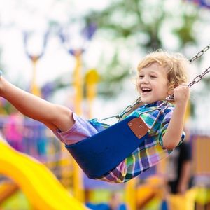 A child swings outdoors.