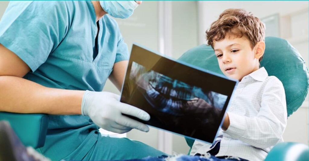 A dentist and a child look at x-rays.