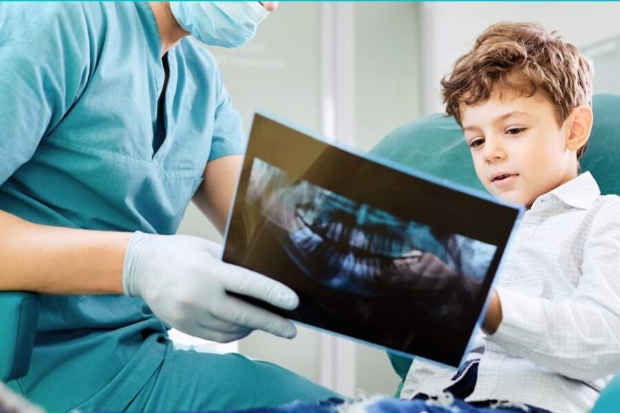 A dentist and a child look at x-rays.