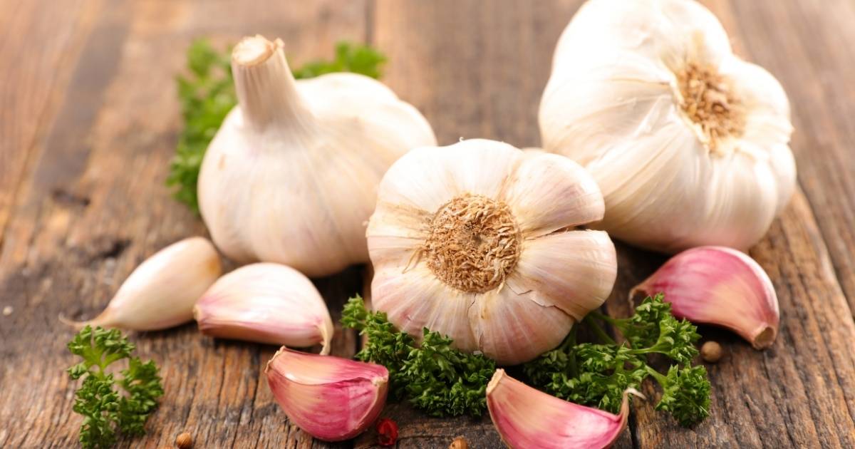 A few cloves of garlic on a wooden surface.