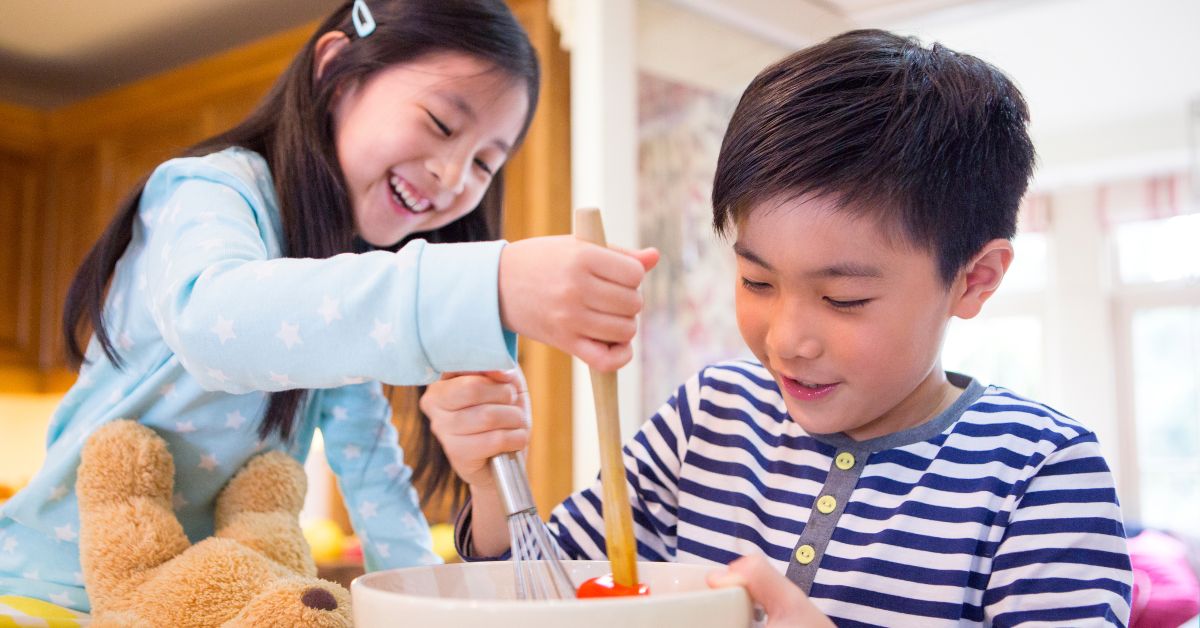Two kids mixing brownies in a bowl.