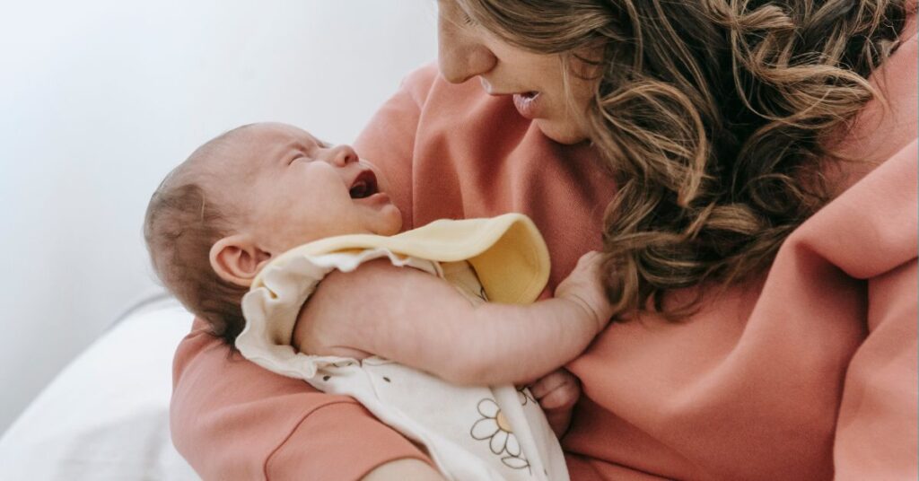 A mother holds a fussy baby.