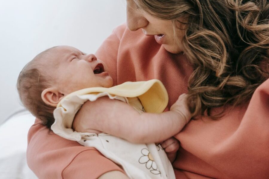 A mother holds a fussy baby.