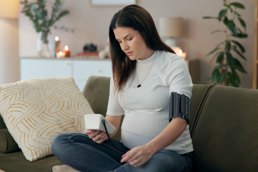 A pregnant woman monitors her blood pressure.
