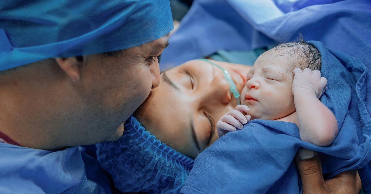 Parents hold their newborn baby immediately after a c-section.