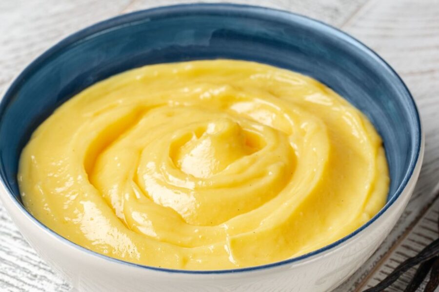 A blue bowl full of yellow custard.