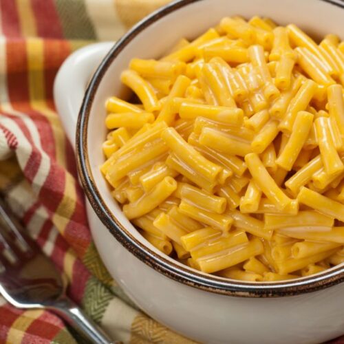 A white bowl filled with mac & cheese.