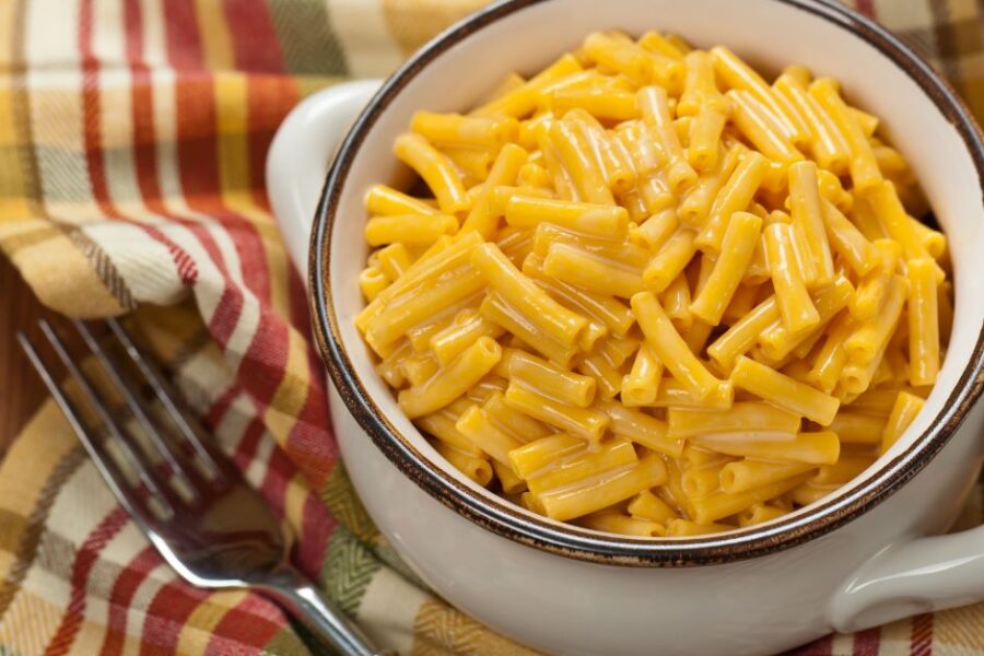 A white bowl filled with mac & cheese.
