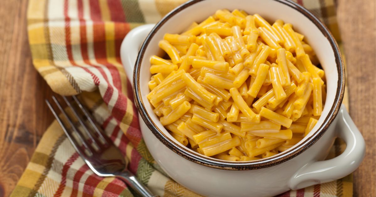 A white bowl filled with mac & cheese.