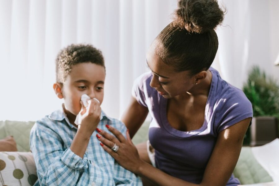 A mother comforts her coughing son.
