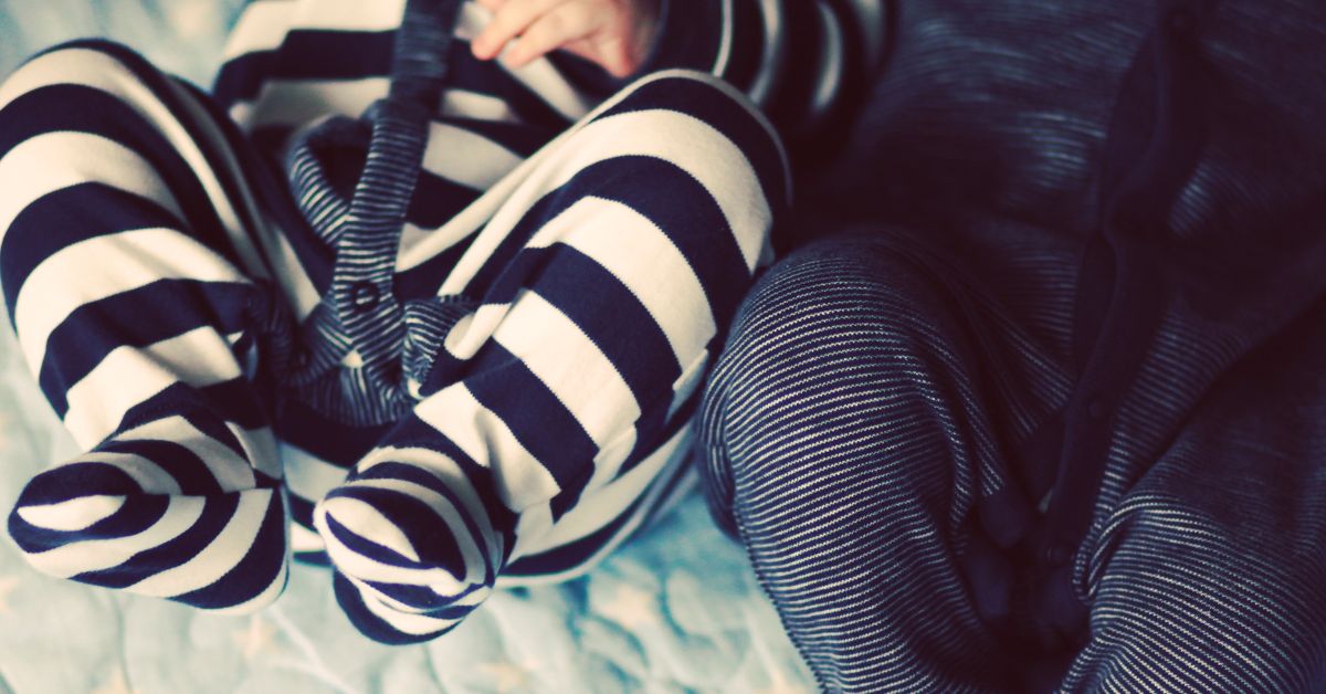 Two babies wearing footie pajamas.